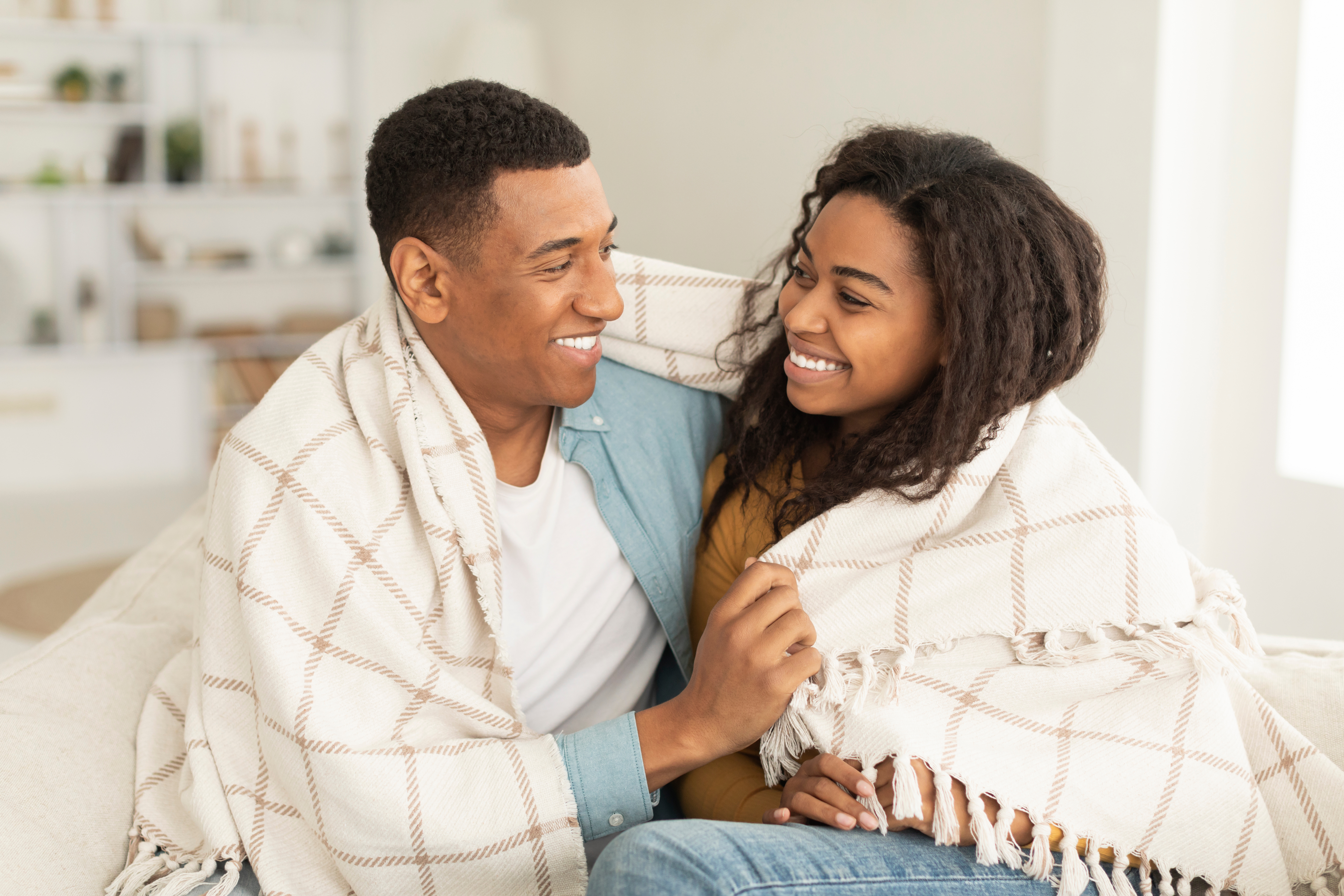 A couple together with a blanket during cold weather - get reliable heating repair in Eagle Mountain, UT to stay warm all season long.