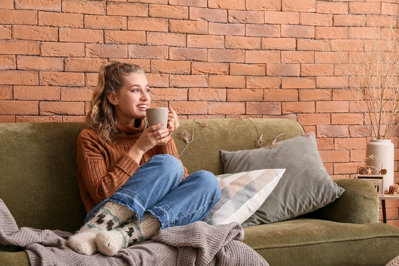 A woman enjoying the warmth of her home - get expert heating installation today with the Ultimate Air Inc team.